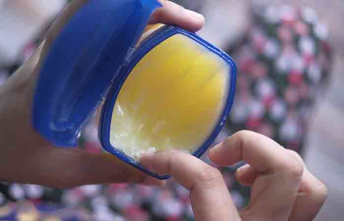 Woman taking out petroleum jelly from the container
