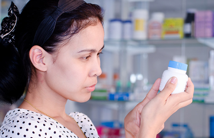 Woman examines the label of an undecylenic acid product