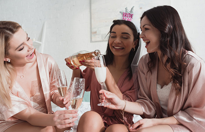 Bride to be pouring champagne for her friends at her bridal shower