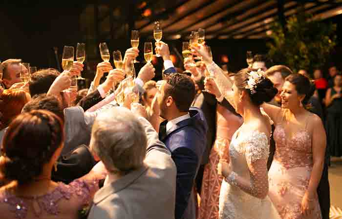 People at a wedding raising their glasses in the air
