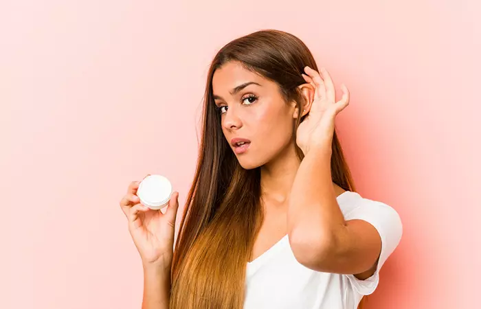 Woman using moisturizer for ear