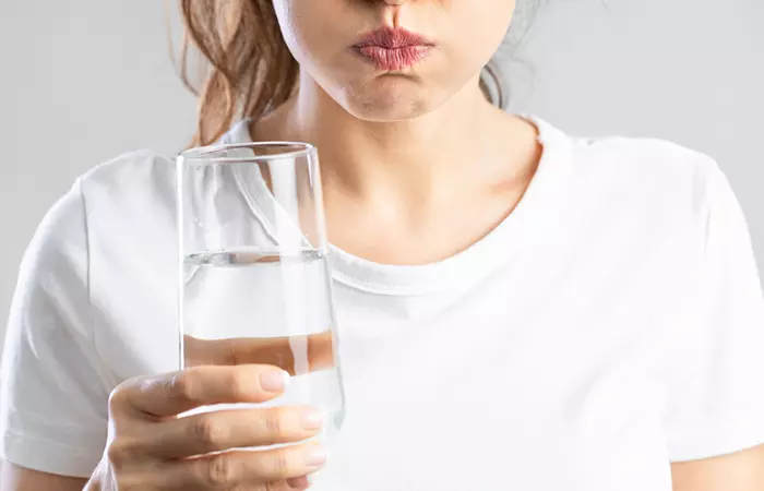 Woman gargling with salt wtaer to treat gum boil