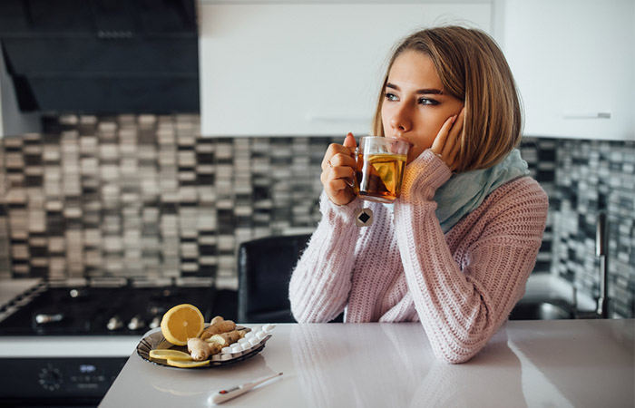 Woman drinking lemon tea to soothe strep throat