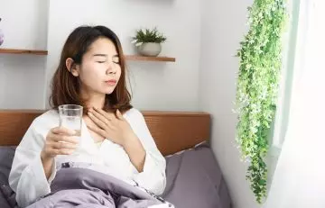 Woman drinking water to keep throat moisturized