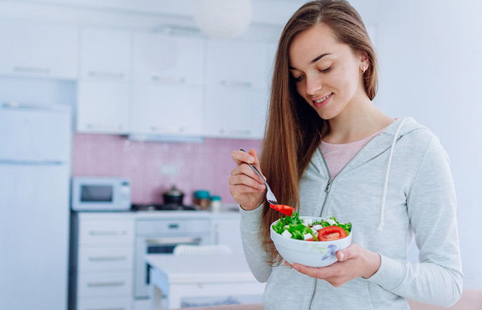 Woman eating low-carb salad to reduce blood sugar levels
