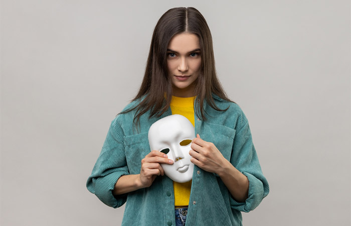 Woman holding a mask to show the concept of change