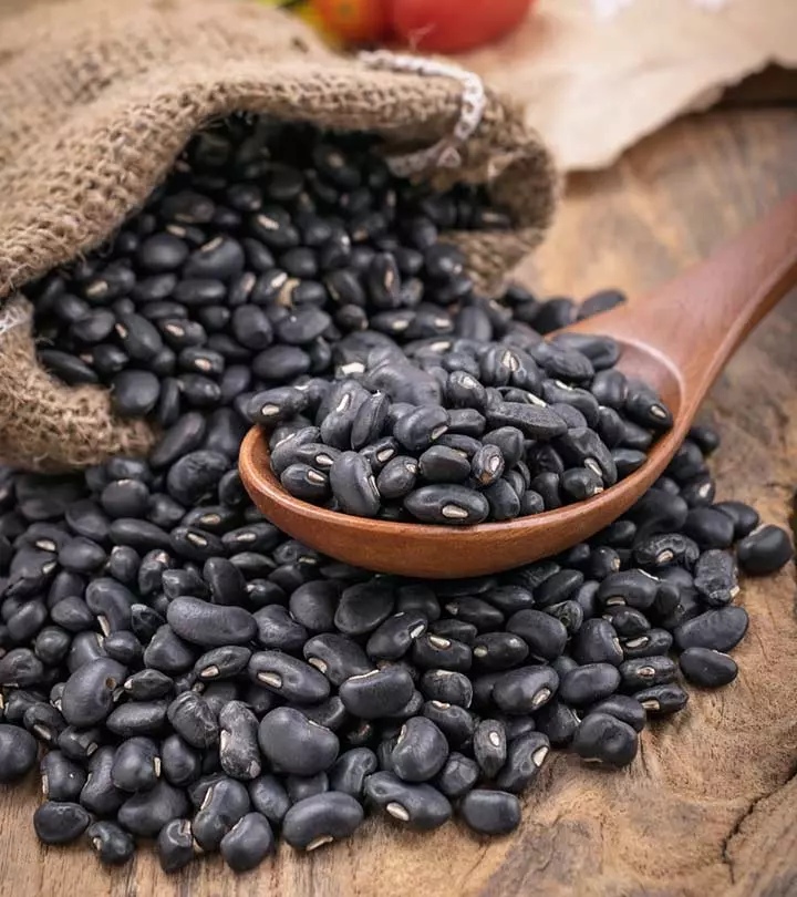 Lots of black beans on a wooden spoon