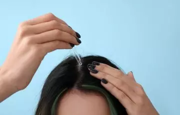 Woman applying Irish hair moss extract on scalp