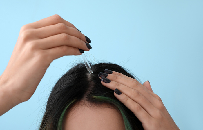 Woman applying Irish hair moss extract on scalp