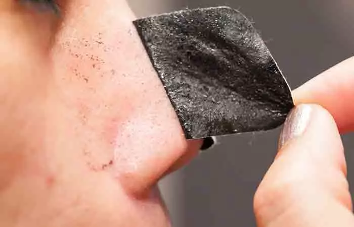Woman applying DIY pore strips on her nose to remove blackheads