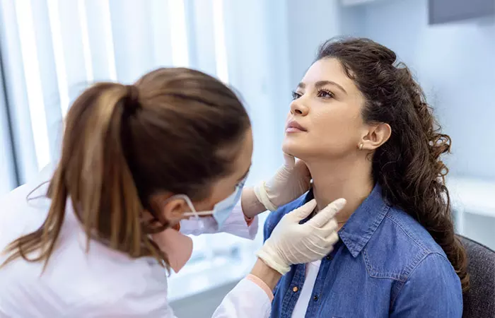 Doctor examining skin tag on a woman's neck