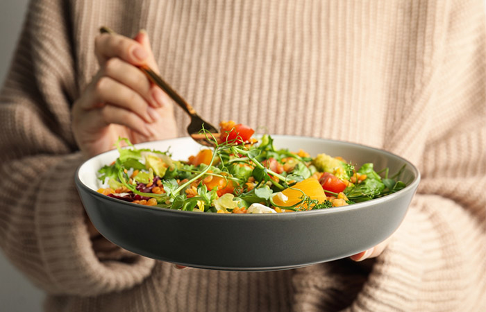 Woman eating salad with microgreens 