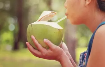 Woman drinking tender coconut water
