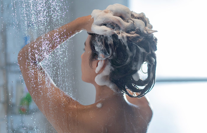 Woman using hydrating shampoo to wash natural hair