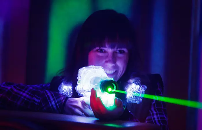 A girl playing laser tag at a teen birthday party