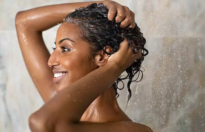 Woman rinsing hair with cold water