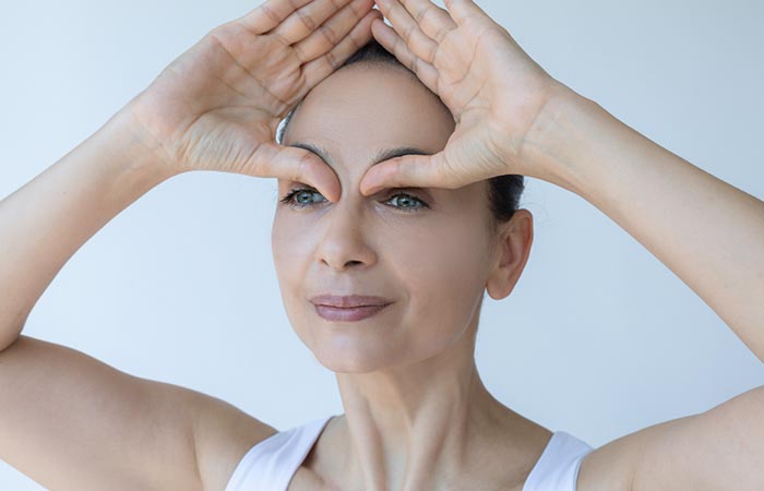 Woman performing 'thumbs next to eyes' exercise
