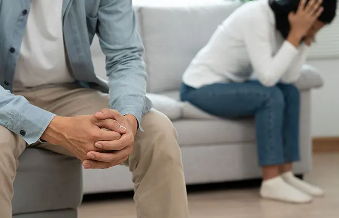 Unhappy couple sitting apart on the couch