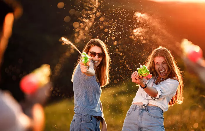 Three teens having a fun water fight at a teen birthday party