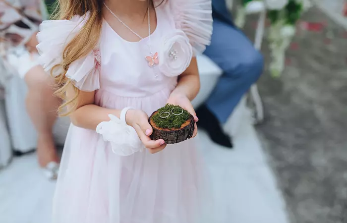 A little girl carrying the rings