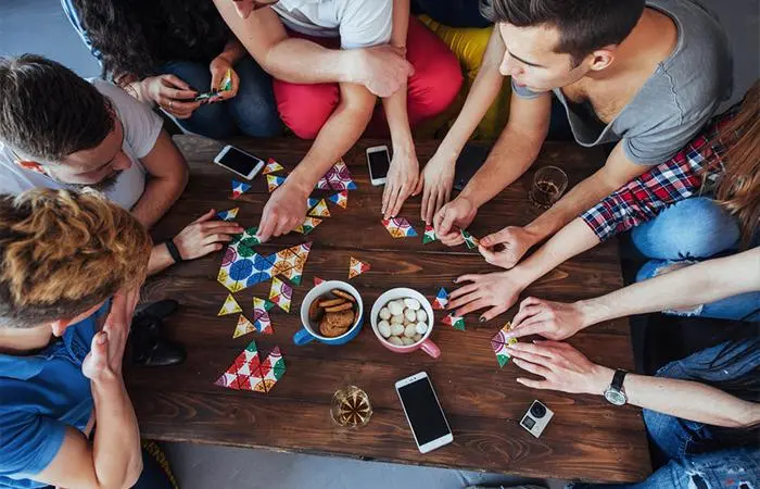 A group of friends playing a game around the table