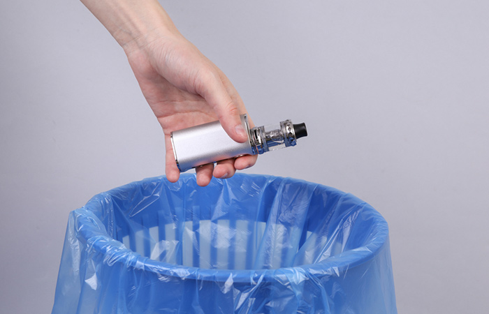 Person throwing vaping device in a bin