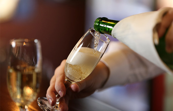 Close up of a man pouring champagne into glass