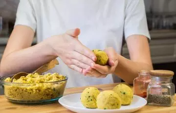 Woman shapes balls of falafel in her kitchen