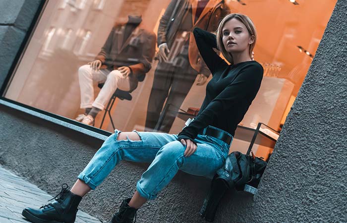 Model wearing a black t-shirt, ripped boyfriend jeans with black ankle boots 