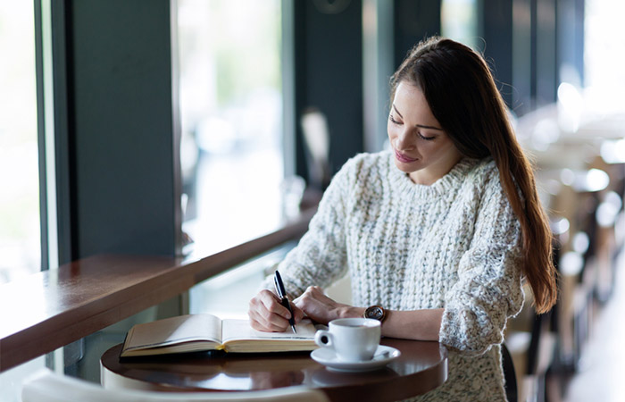 Woman smiling while writing down partner's traits