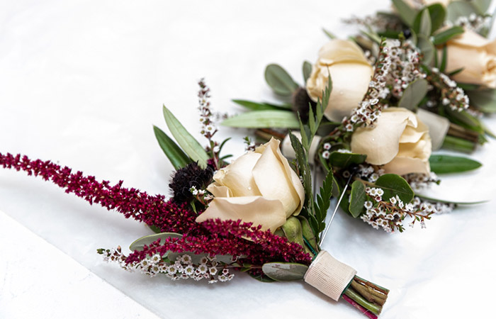 Flowers and dried leaves tied with floral tape for a boutonniere