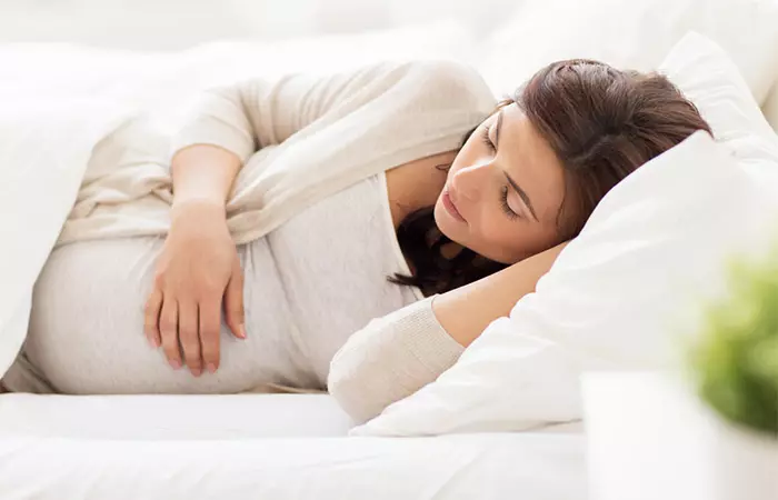 Pregnant woman with cold getting rest to assuage her symptoms