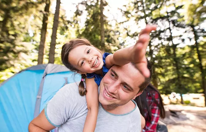 Father and daughter enjoying a lovely camping trip in the woods.