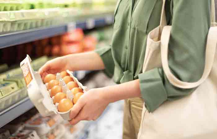 Woman buying brown eggs