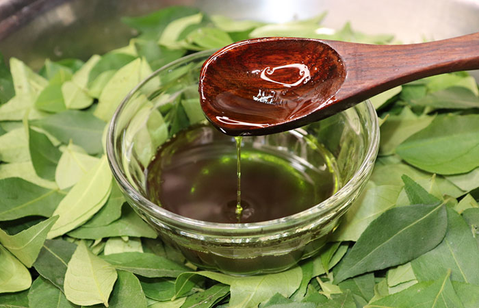 Bowl of hair oil made with curry leaves
