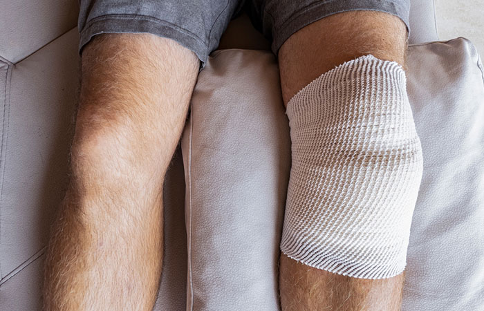 Man with castor oil wrap for knee pain