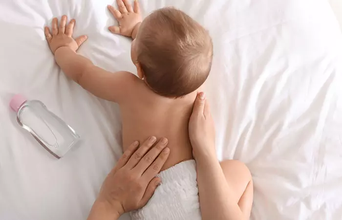 Mother massaging baby with baby oil