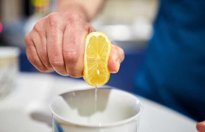 Person squeezing fresh lemon juice