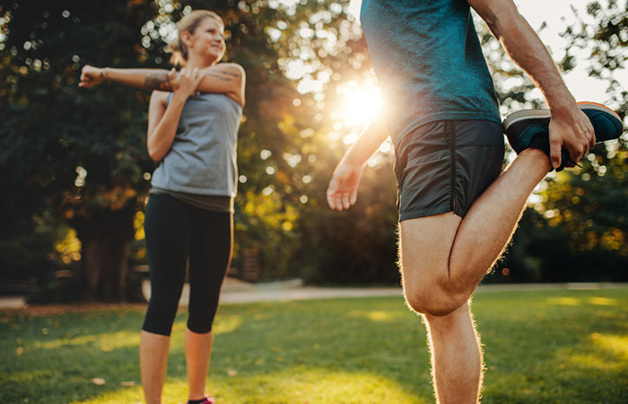 Woman and man doing warm-up before jogging