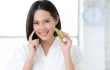 Woman applying aloe vera to prevent peeling skin