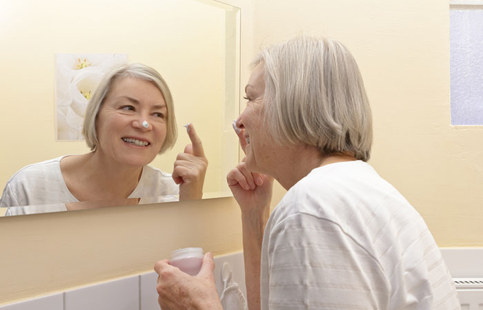 Woman applying cream to prevent an oily nose