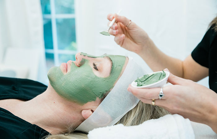 Woman applying green tea on face to reduce inflammation