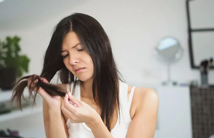 Woman checking hair split ends
