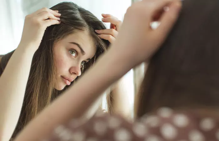 Woman checking her hair and scalp after using hyaluronic acid