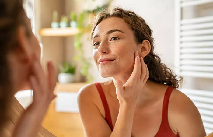 Woman checks out her skin after using black seed oil