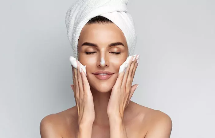 Woman cleansing her face as part of the French skincare routine