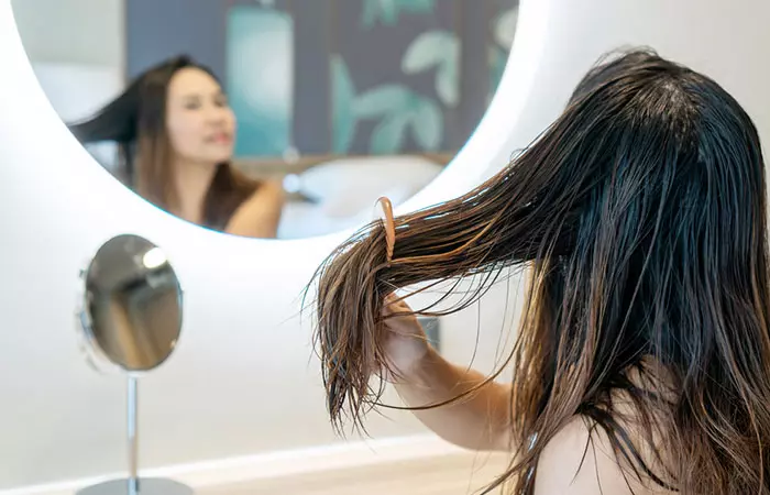 Woman detangling her hair with hair serum