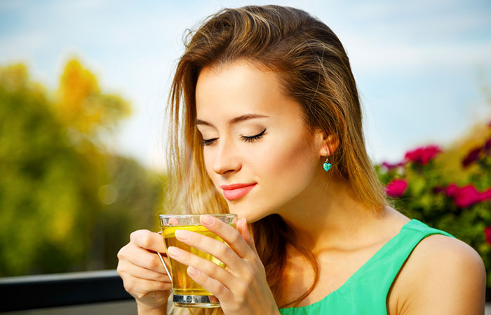 Woman drinking green tea to control hair fall