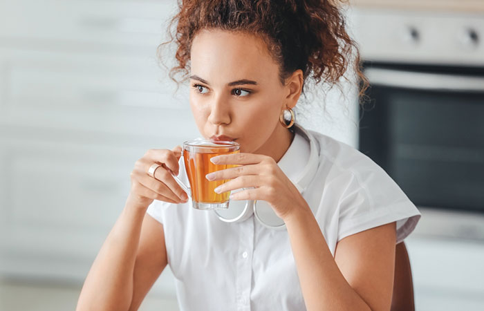Woman drinking lemongrass tea to improve skin health