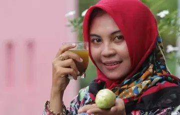 Woman drinking noni juice.